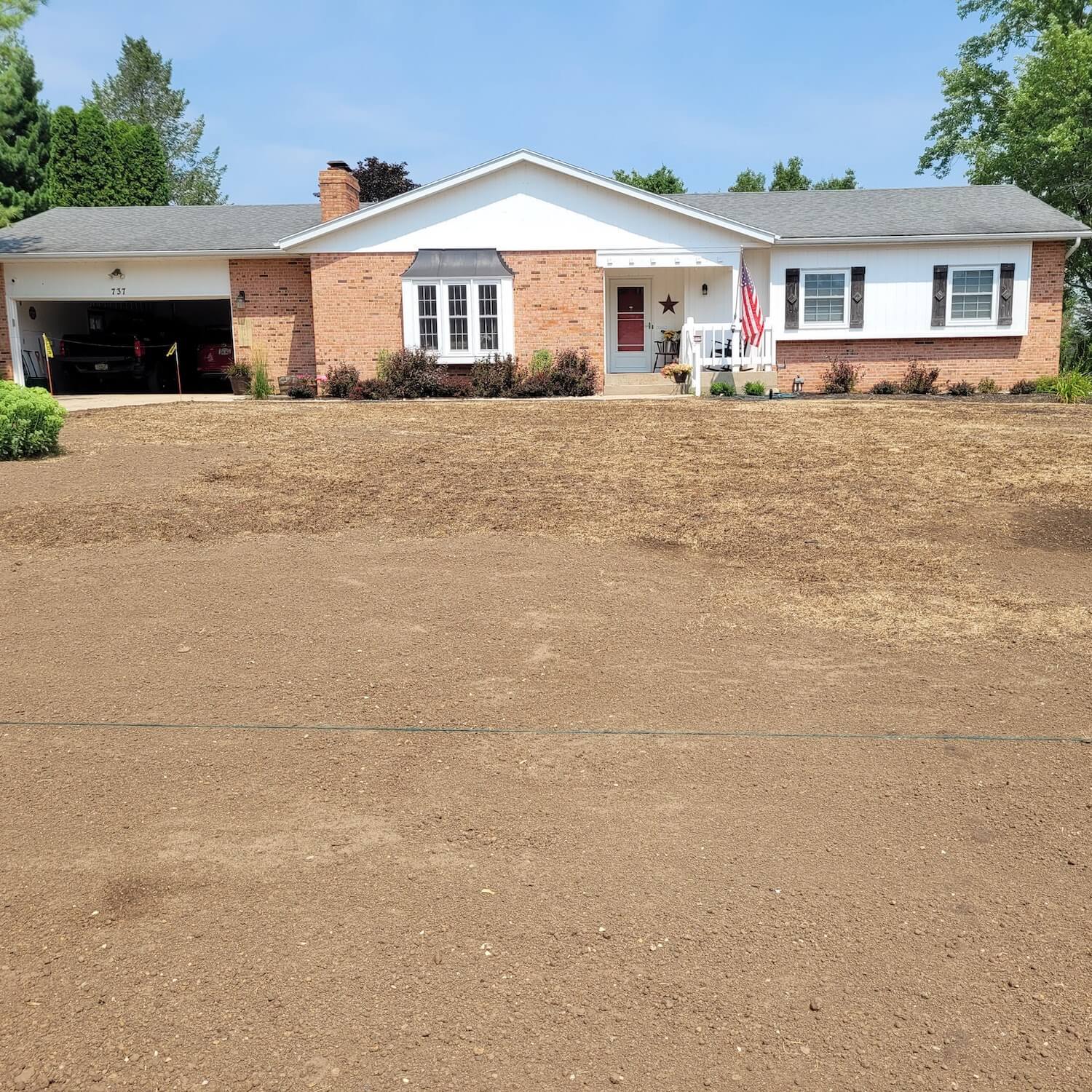 A single-story suburban house with a newly seeded front lawn.