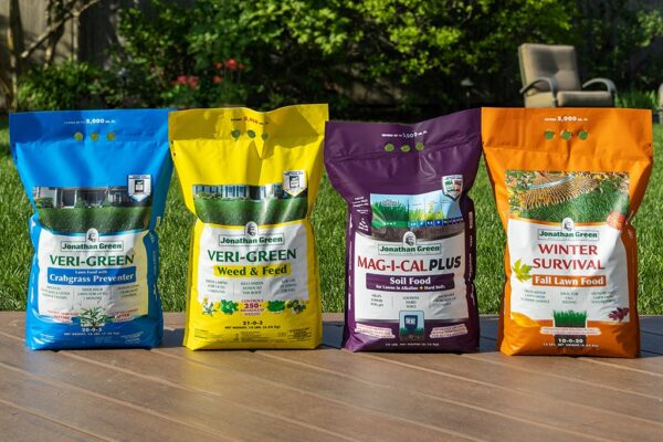 Four different types of Jonathan Green Annual Lawn Care Program for Alkaline Soil products displayed in a row on a sunny day.