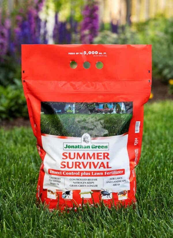 A bag of Summer Lawn Care Bundle, including summer survival insect control plus lawn fertilizer in a garden setting.