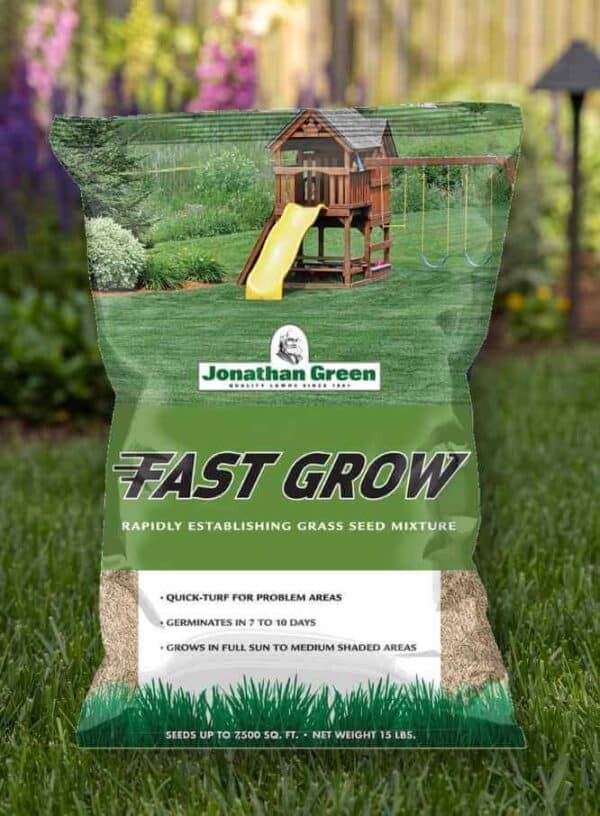 A bag of Fast Grow Grass Seed in a garden setting with a playhouse in the background.