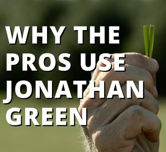A close-up of a hand grasping a small bunch of grass with the text overlay "why the turf-pros use Jonathan Green".